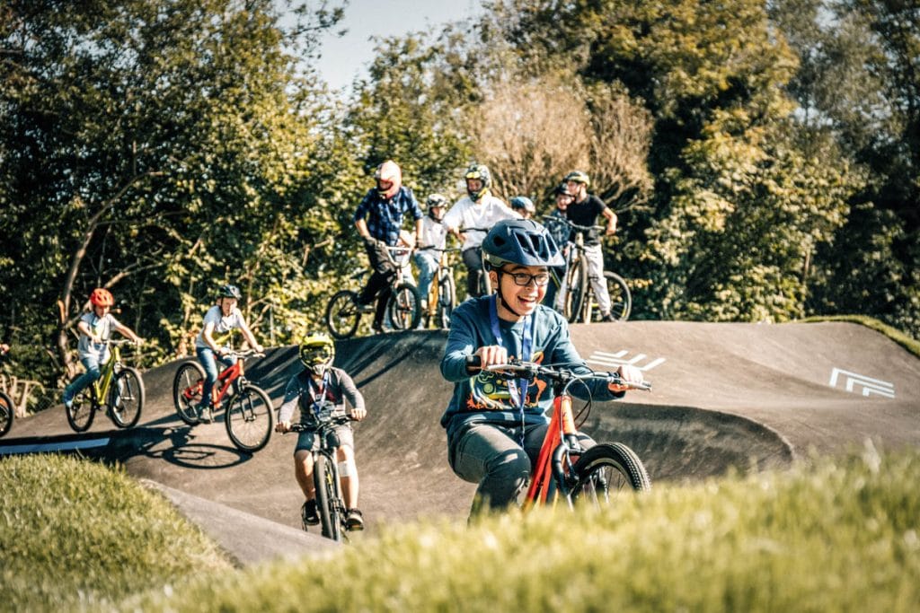 Lachende Kinder auf einem Pumptrack.
