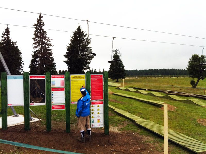 A man looking at the bike park sign with rules